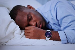 man,wearing,black,smartwatch,tracks,sleep,during,late,night,napping.